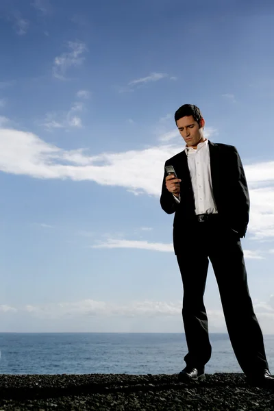 Man in coat and tie with mobile phone — Stock Photo, Image