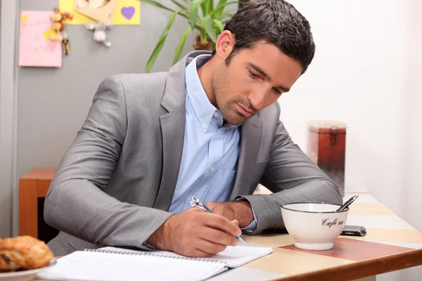 Businessman working at his breakfast bar — Stock Photo, Image