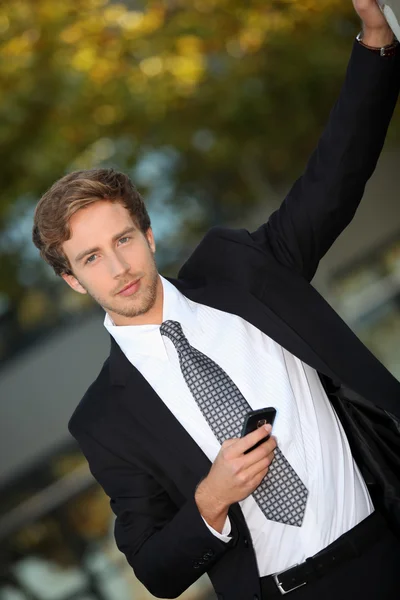 Jonge man in slimme pak met mobiele telefoon — Stockfoto