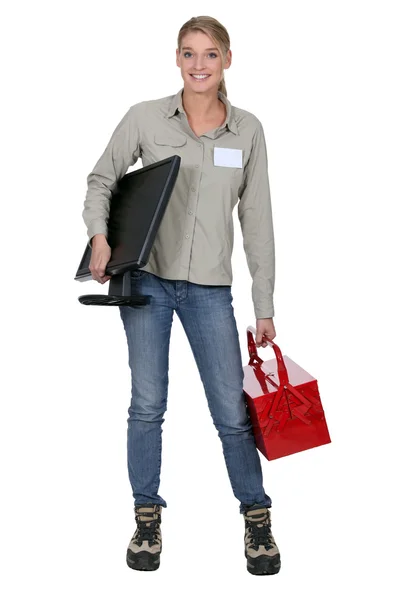 Mulher loira segurando uma tela de computador e uma caixa de ferramentas — Fotografia de Stock