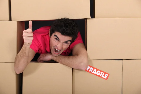 Mannen omgiven av lådor — Stockfoto
