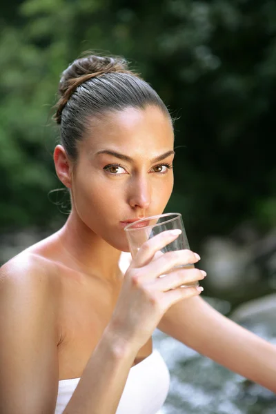 Frau trinkt Glas Wasser am Bach — Stockfoto