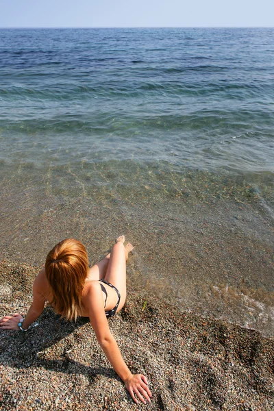 Молода жінка лежить на піску — стокове фото