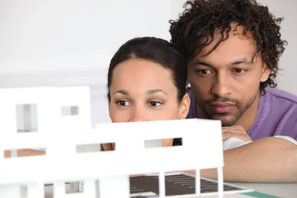 Paar kijken naar model huisvesting — Stockfoto