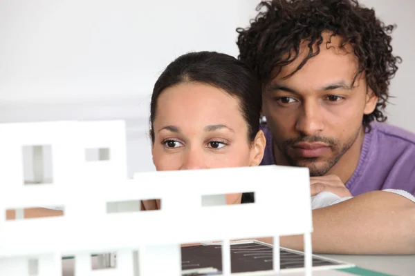 Pareja mirando el modelo de vivienda — Foto de Stock