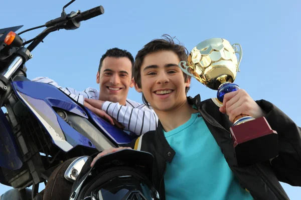 Πατέρας και γιος, κρατώντας το τρόπαιο μετά από αγώνα μοτοσικλέτας — Φωτογραφία Αρχείου