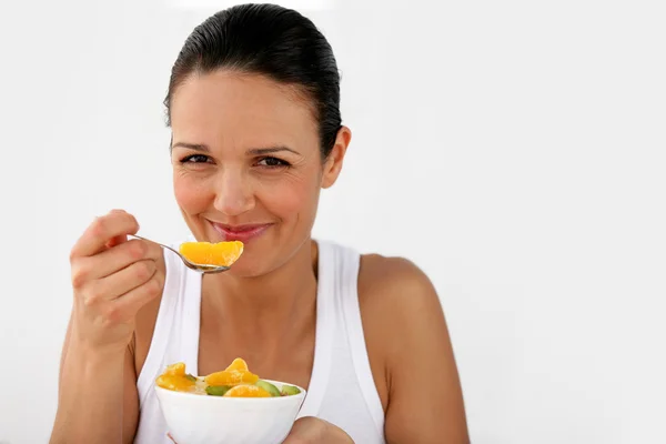 Vrouw een schaal met fruit eten — Stockfoto