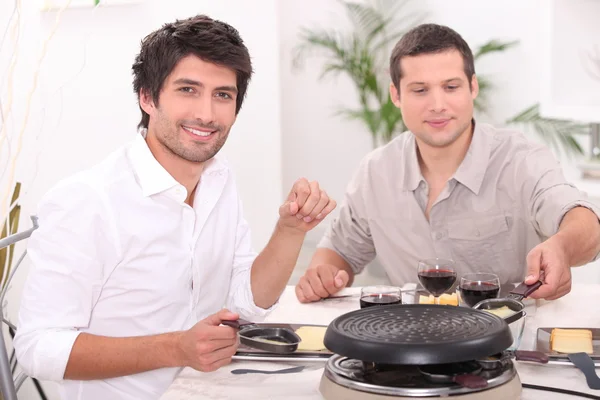 Männer essen Raclette — Stockfoto