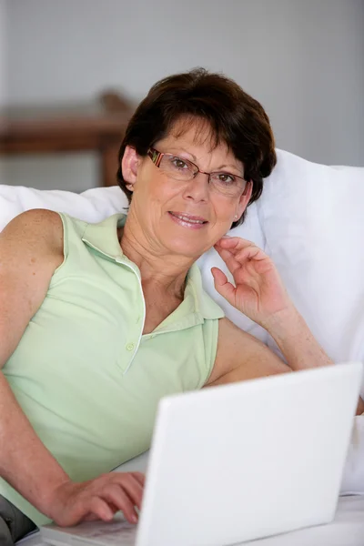 Nő rajta laptop használ a nappaliban — Stock Fotó