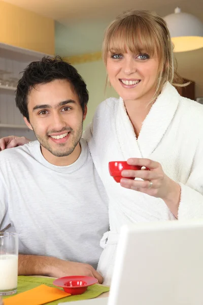 Paar ontbijten voor hun laptop — Stockfoto