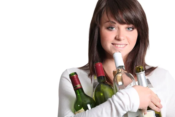Ung kvinna med tomma vinflaskor — Stockfoto