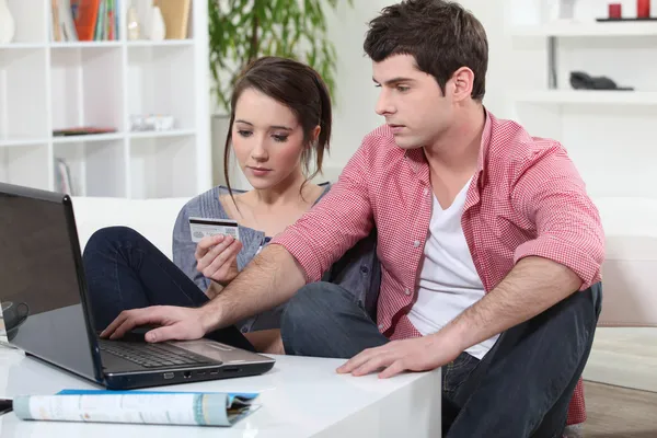Ung man och ung kvinna att göra shopping online — Stockfoto