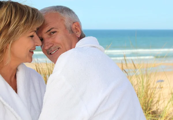 Older couple smooching in the sand dunes Stock Picture