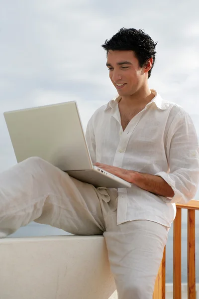 Man using his laptop on hotel balcony — Stock Photo, Image