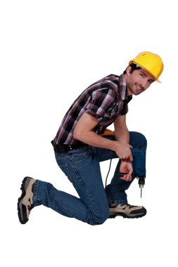 Man kneeling with drill clipart