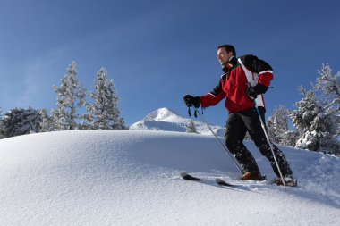 A man skiing in the snowy country clipart