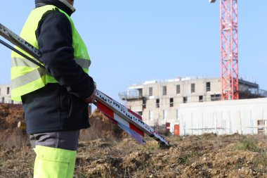 Builder in construction site near crane clipart