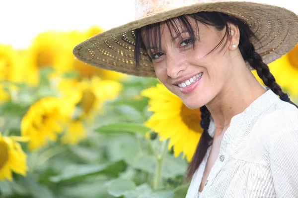 Женщина в соломенной шляпе на подсолнечном поле — стоковое фото