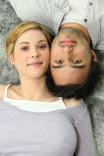 Ένα ζευγάρι ξαπλωμένο σε ένα χαλί — Φωτογραφία Αρχείου