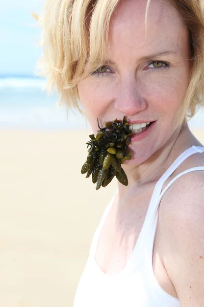 Woman with seaweed in mouth — Stock Photo, Image