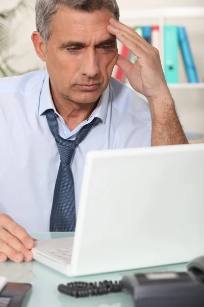 Seriöser Geschäftsmann arbeitet an seinem Laptop — Stockfoto