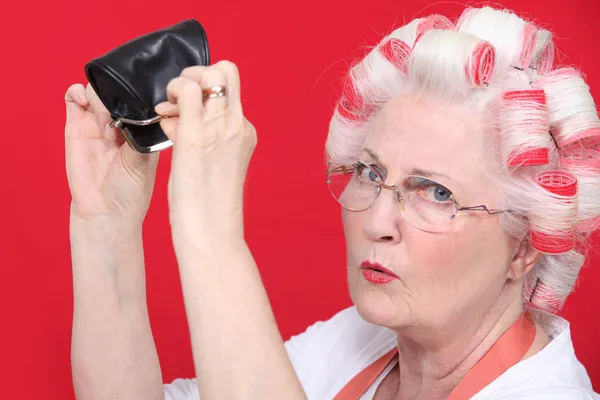 Grandma with hair curlers and empty purse — Stock Photo, Image