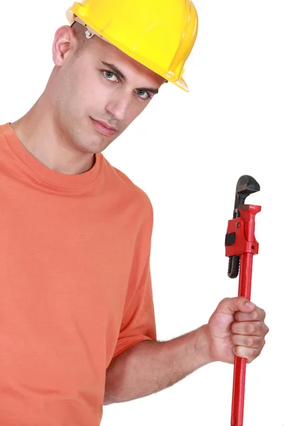 Jovem handyman careca segurando chave ajustável — Fotografia de Stock