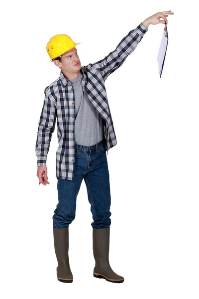 A repulsed tradesman dangling a clipboard — Stock Photo, Image