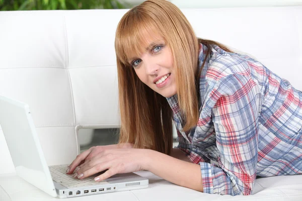 Mujer jengibre se acostó con el ordenador portátil —  Fotos de Stock