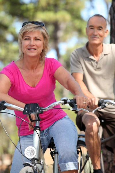 60 ans homme et femme faisant du vélo — Photo