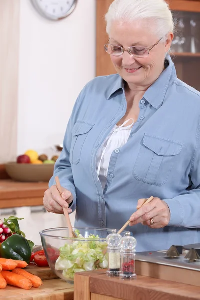 Стара дама робить салат . — стокове фото
