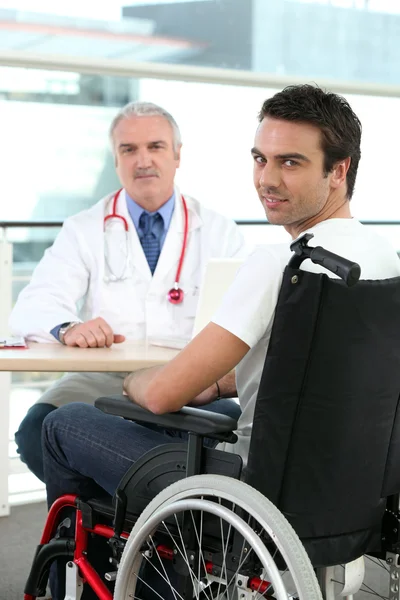 一个医生和一个坐在轮椅上的病人 — 图库照片