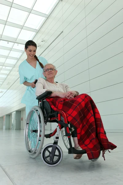 En sjuksköterska och en gammal dam i rullstol — Stockfoto