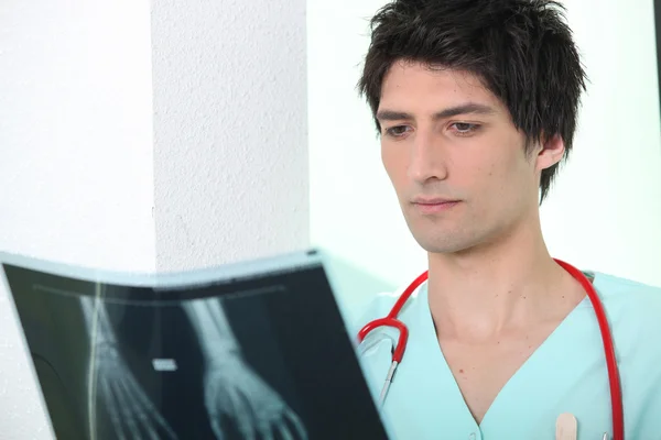 Чоловіча медсестра дивиться на рентгенівське зображення — стокове фото