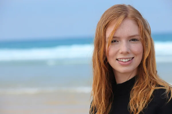 Teenage girl on beach in wetsuit — Stock Photo, Image