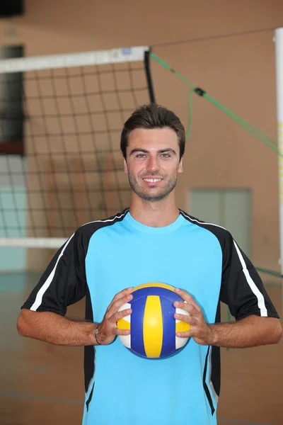 Volleyboll spelaren med bollen framför nätet — Stockfoto