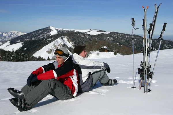 Лыжники, сидящие на снегу — стоковое фото