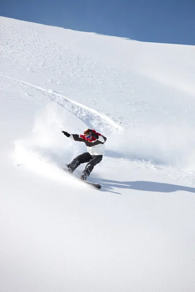 Bir dağdan aşağı kayan bir snowboarder — Stok fotoğraf
