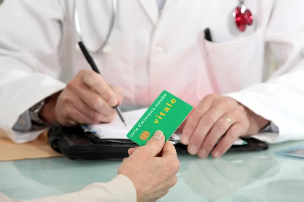 stock image A patient giving a card to a doctor