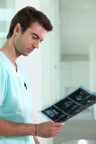 Male nurse examining x-ray image — Stock Photo, Image