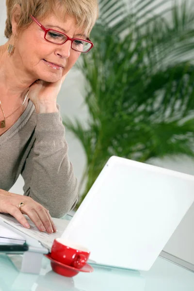 Kobieta o kawę podczas korzystania z laptopa — Zdjęcie stockowe