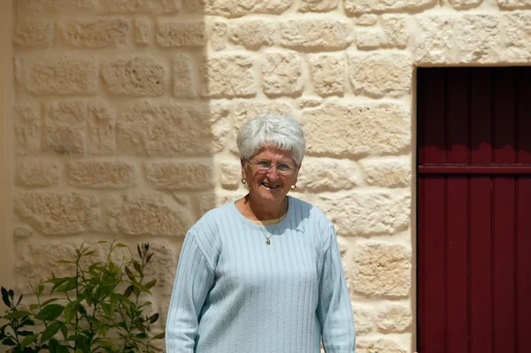 Grijs-haired dame buiten haar huis — Stockfoto
