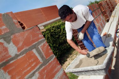 Mason constructing a wall alone clipart