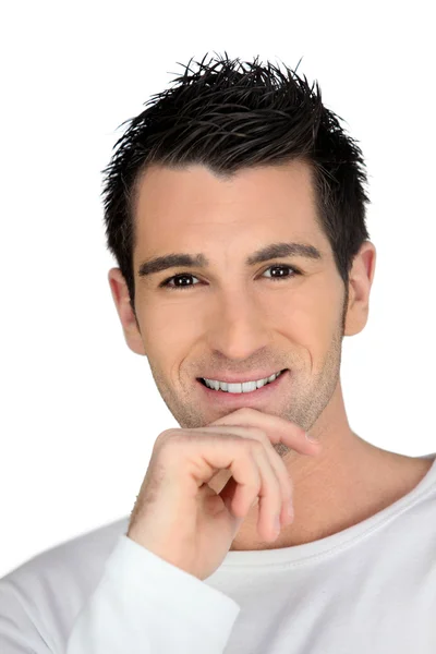 Człowiek uśmiechający się z ręką na brodę — Zdjęcie stockowe