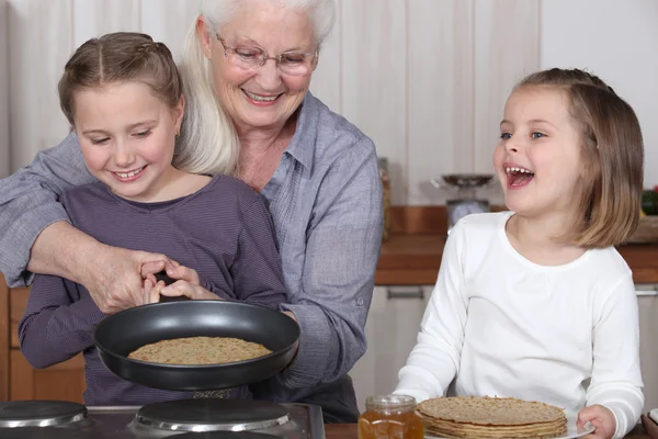stock image Grandmother and granddaughters making pancakes