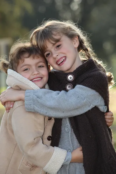 2 つの小さな女の子を抱い入札シーン — ストック写真