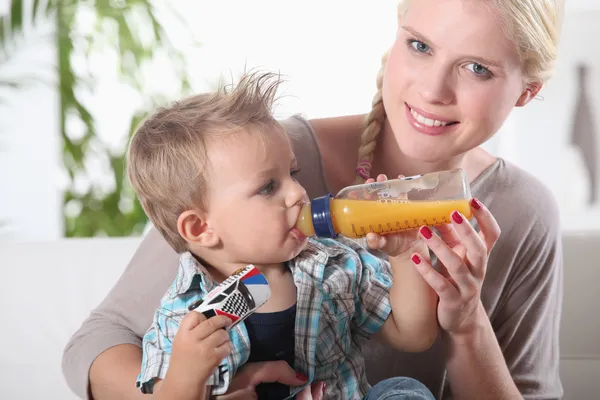 Porträtt av en kvinna som matar sin son — Stockfoto