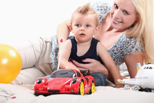 Young woman playing with a little boy and his toys — Stock Photo, Image