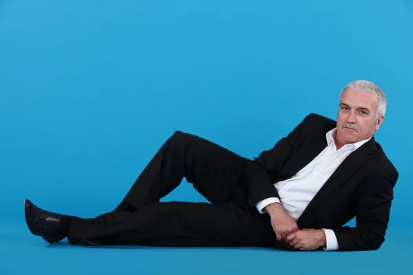 Senior Geschäftsmann auf dem Boden liegend — Stockfoto