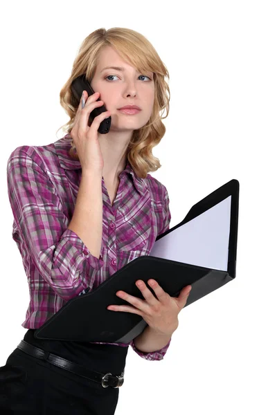 Businesswoman holding a folder and talking on the phone — Stock Photo, Image
